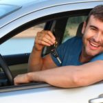 a smiling man leans out his car window, car keys in hand and looking happy about the ASX All Ordinaries company SG Fleet's share price performance this week.