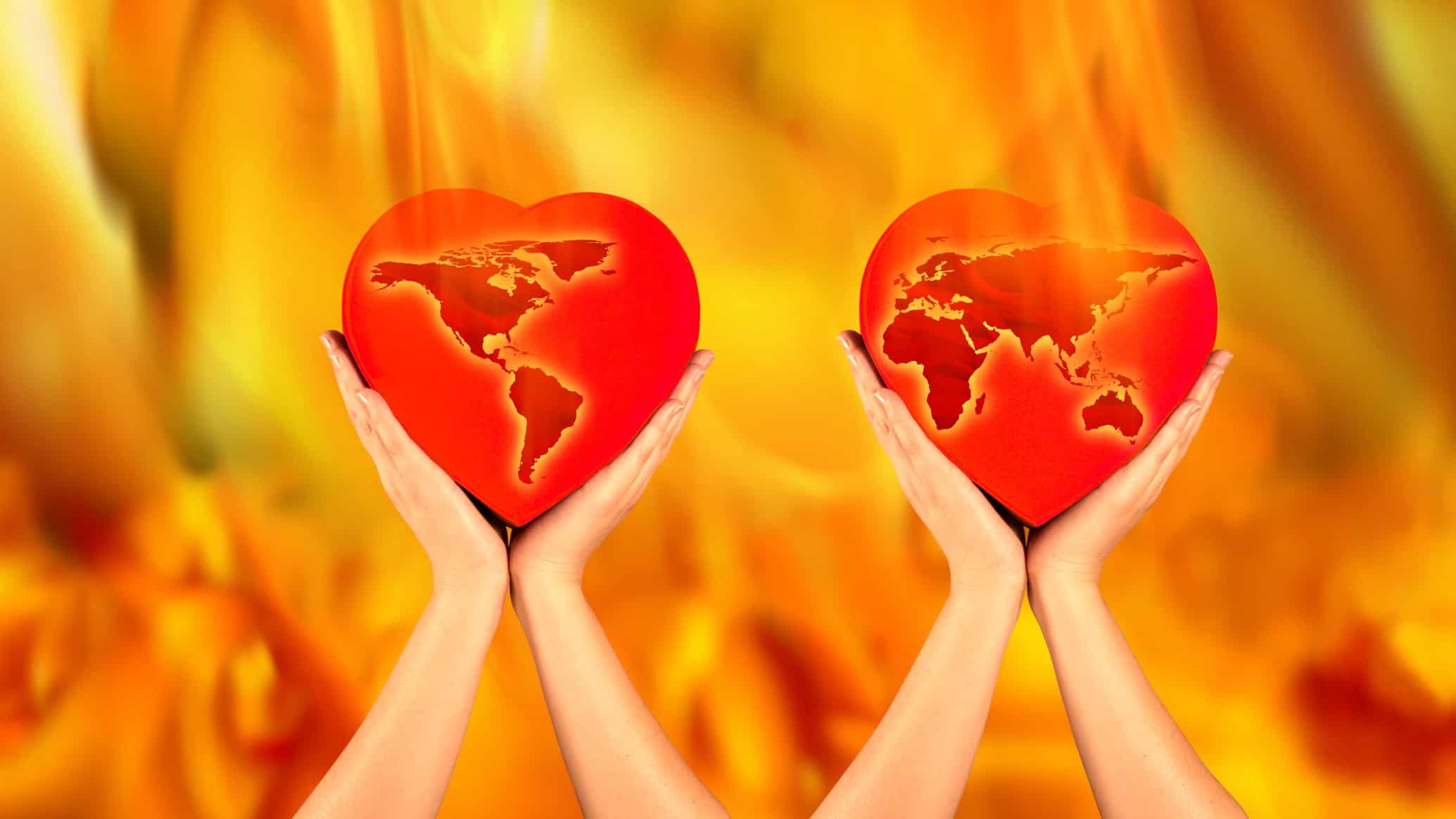 graphic image of the map of the globe held in two hands against the backdrop of burning flames.