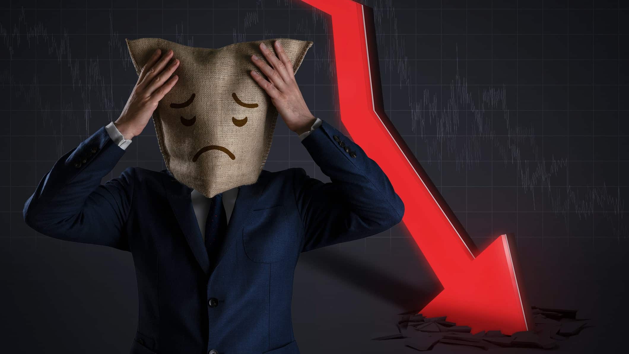 a person wearing a sad faced bag on his head stands with hands to head in front of a red arrow plunging into the ground, denoting a falling share price.