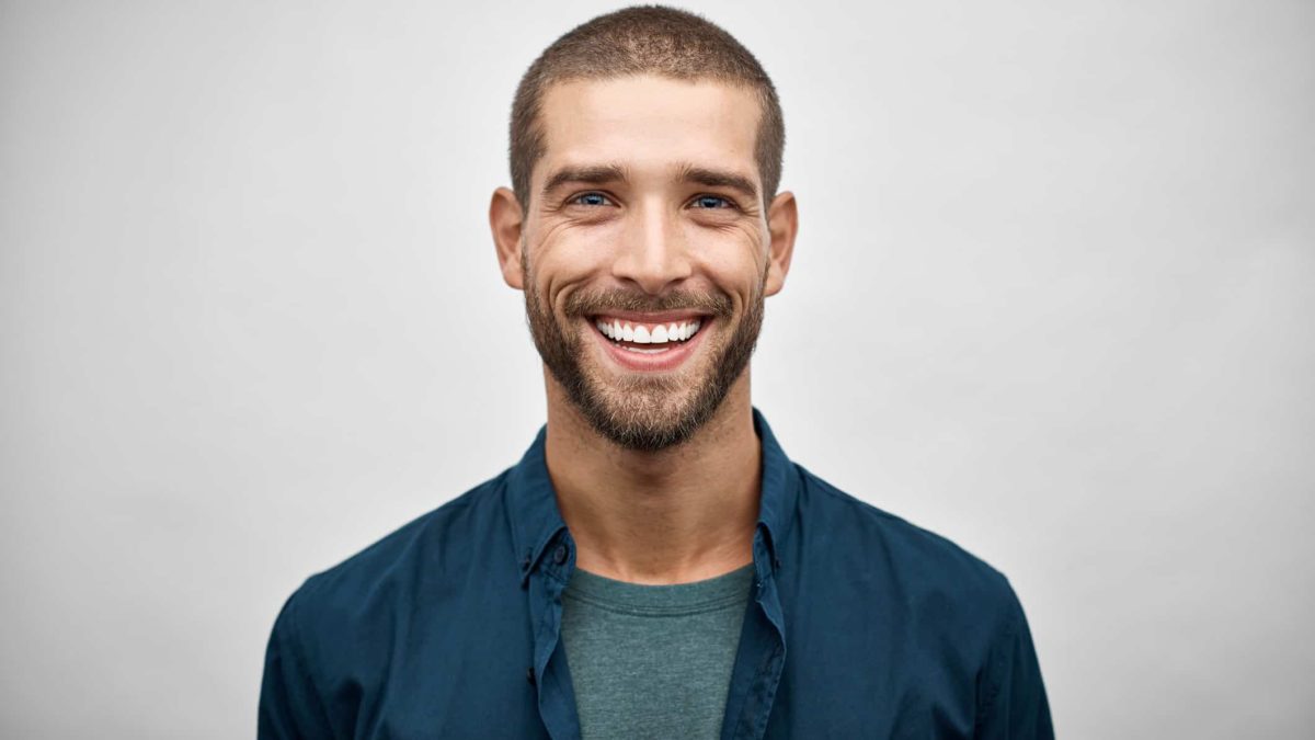 young man smiling in blue shirt