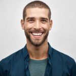 young man smiling in blue shirt