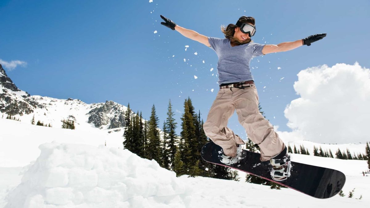 Female snowboarder flies high in the clouds.