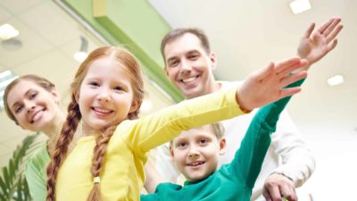 Family of four celebrating inside a grocery store or supermarket