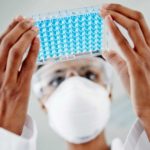 Lab technician in lab with a tray of specimens