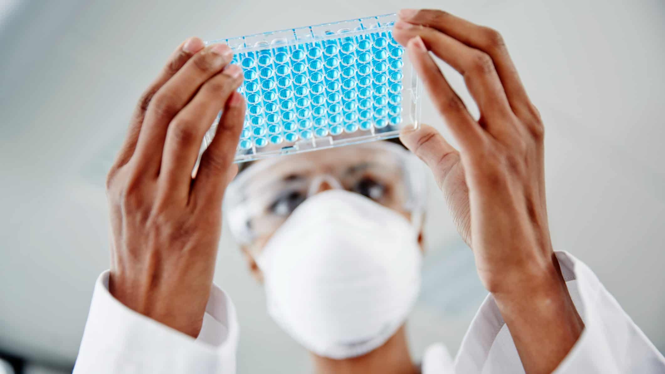 Lab technician in lab with a tray of specimens