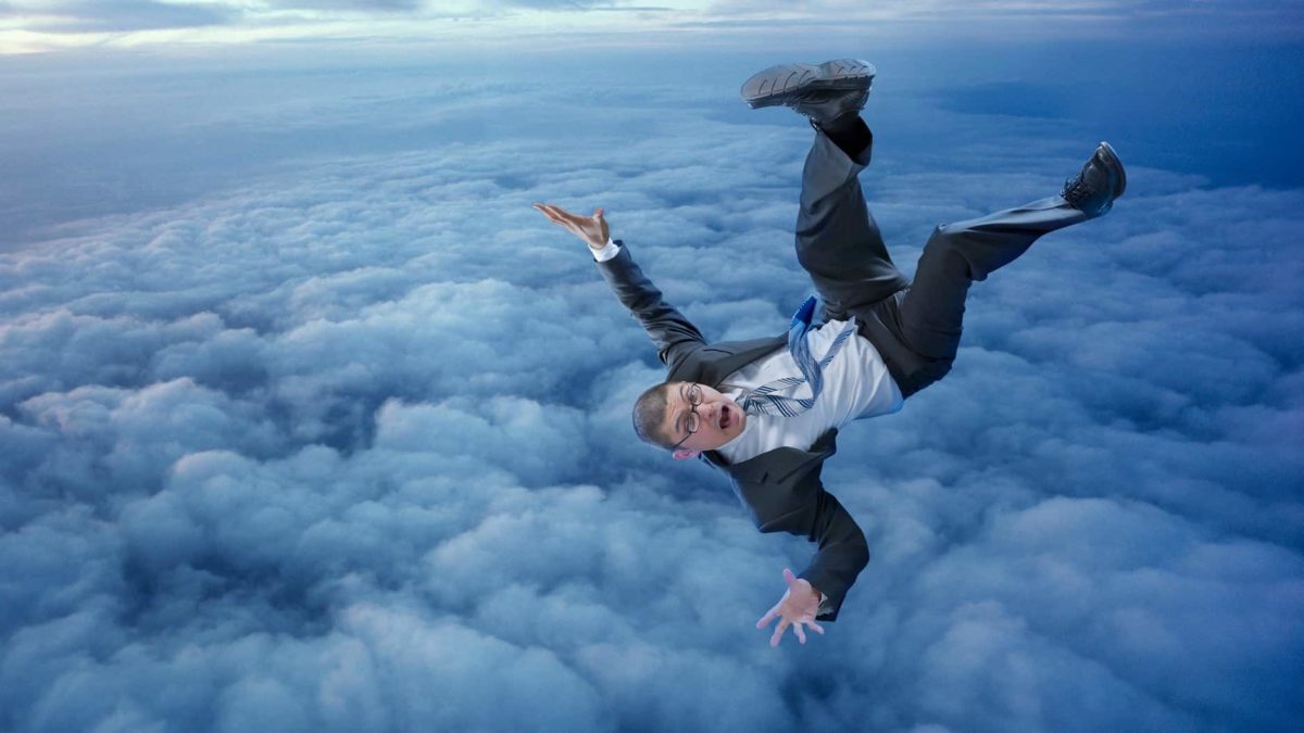 Man in business suit above the clouds plummeting downwards back first