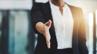 businesswoman holds hand out to shake