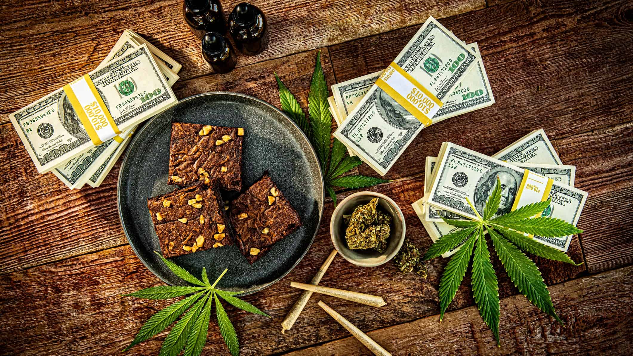 cannabis brownies and joints surrounded by dollar bills