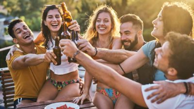 A group of young friends celebrating and toasting with beers