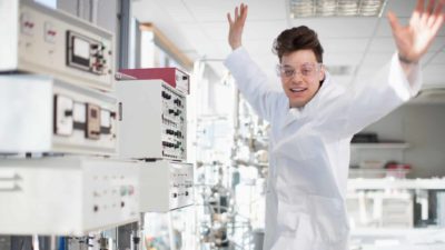 Lab worker puts hands in the air and dances around