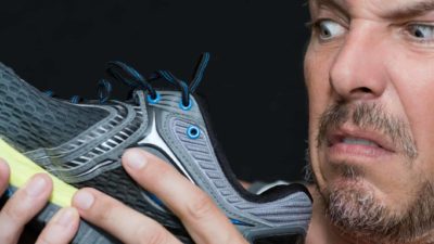 Close-up of man looking at trainer/sneaker and grimacing