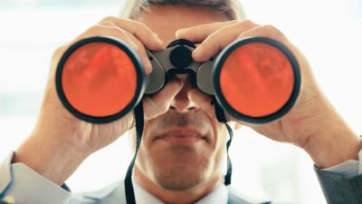 man looking through binoculars