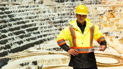 Miner standing at quarry looking upset