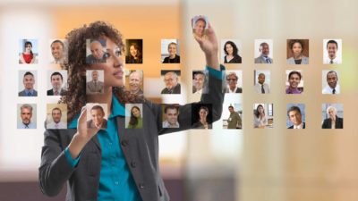 Businesswoman organizing photo portraits of colleagues on touch screen