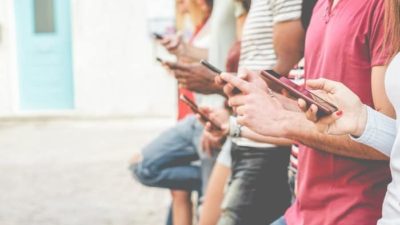 group of friends checking facebook on their smartphones