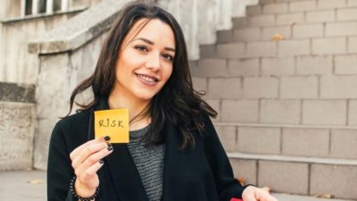 woman holding a sticky note with the word risk