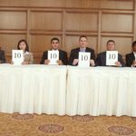 An old-fashioned panel of judges each holding a card with the number 10