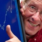 Man puts thumb up next to stock market graph