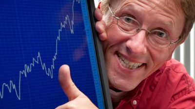 Man puts thumb up next to stock market graph