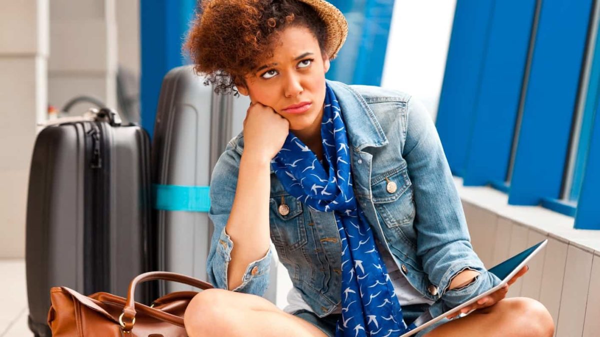 Woman sitting looking miserable at airport