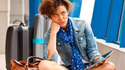 Woman sitting looking miserable at airport