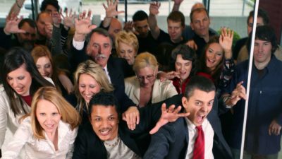 A group of people push and shove through the doors of a store, trying to beat the crowd.