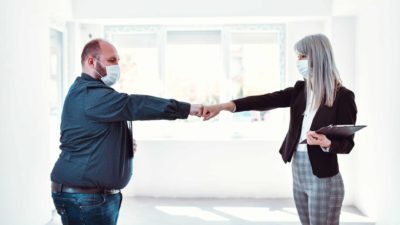 A man and woman touch knuckles signifying success in their venture.