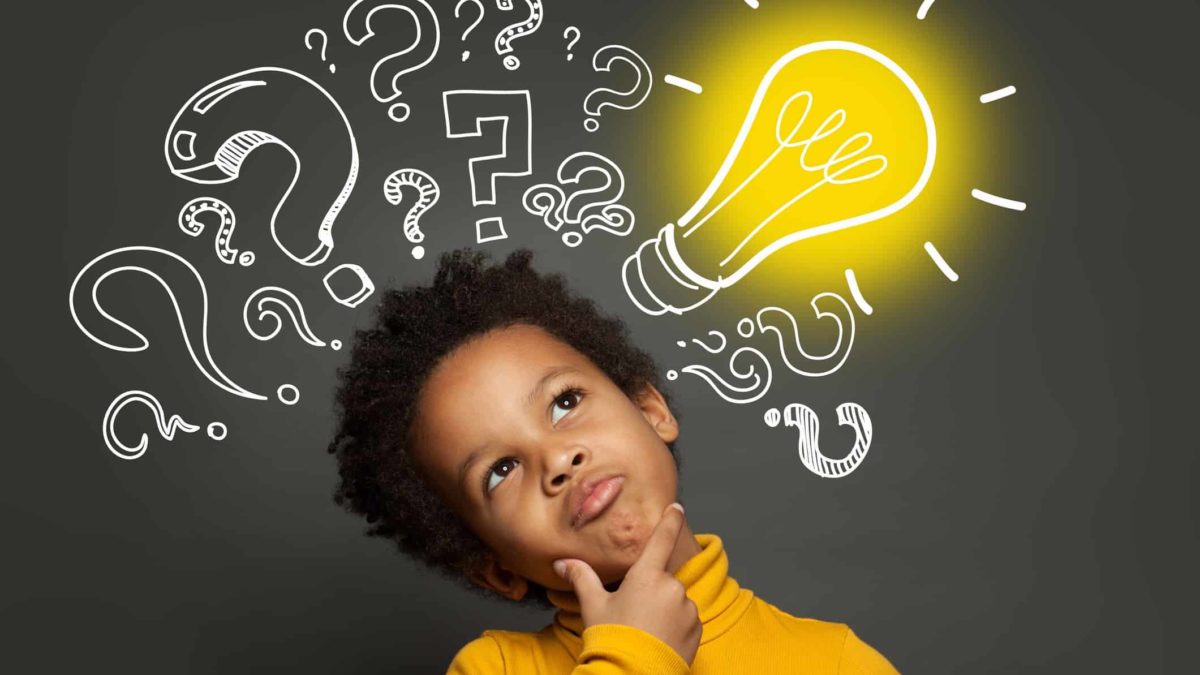 a small child holds his chin with his head on the side in a serious thinking pose against a background of graphic question marks and a yellow lightbulb.