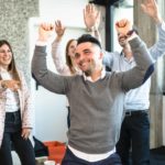 a group of young people dance together with their hands in the air, moving to music as they celebrate ASX 200 shares rising today.