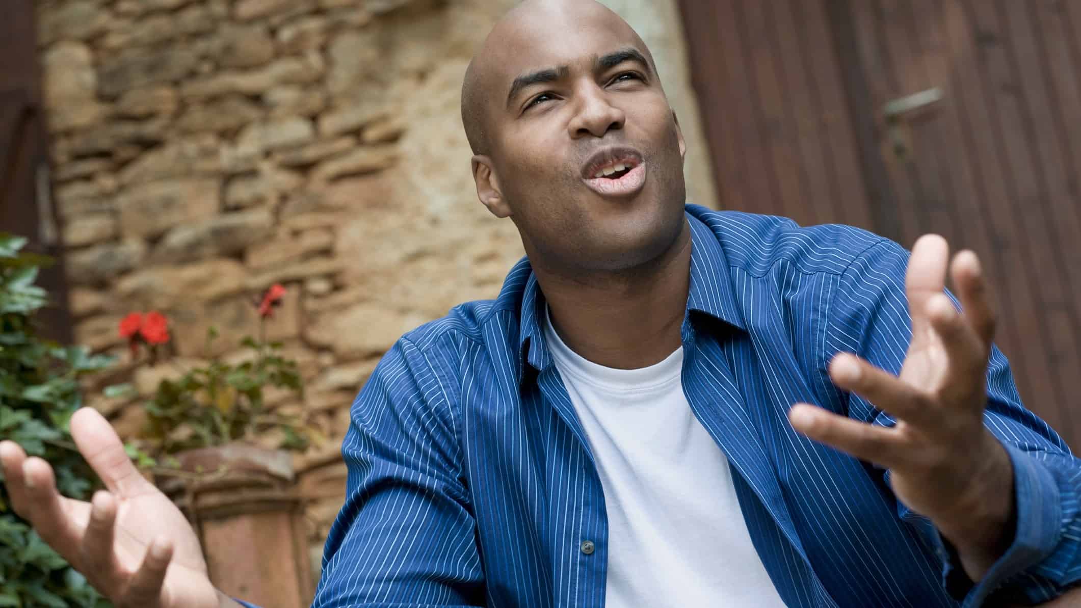 a person with an uncomfortable, questioning expression and arms outstretched as if asking why?