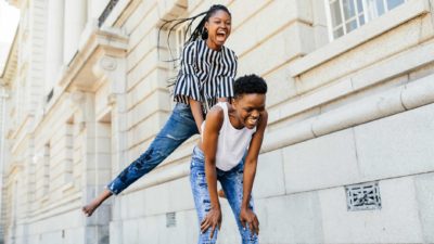 One girl leapfrogs over her friend's back.