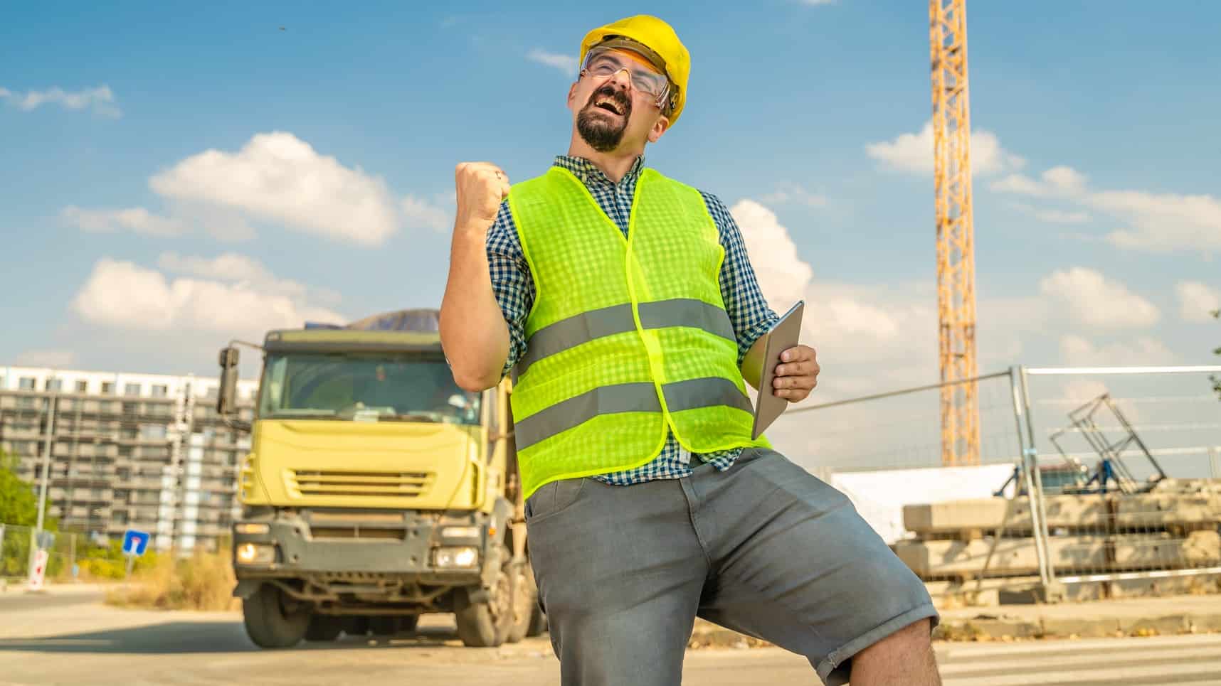 Man on construction site wearinf hard hat and fluoro cheers