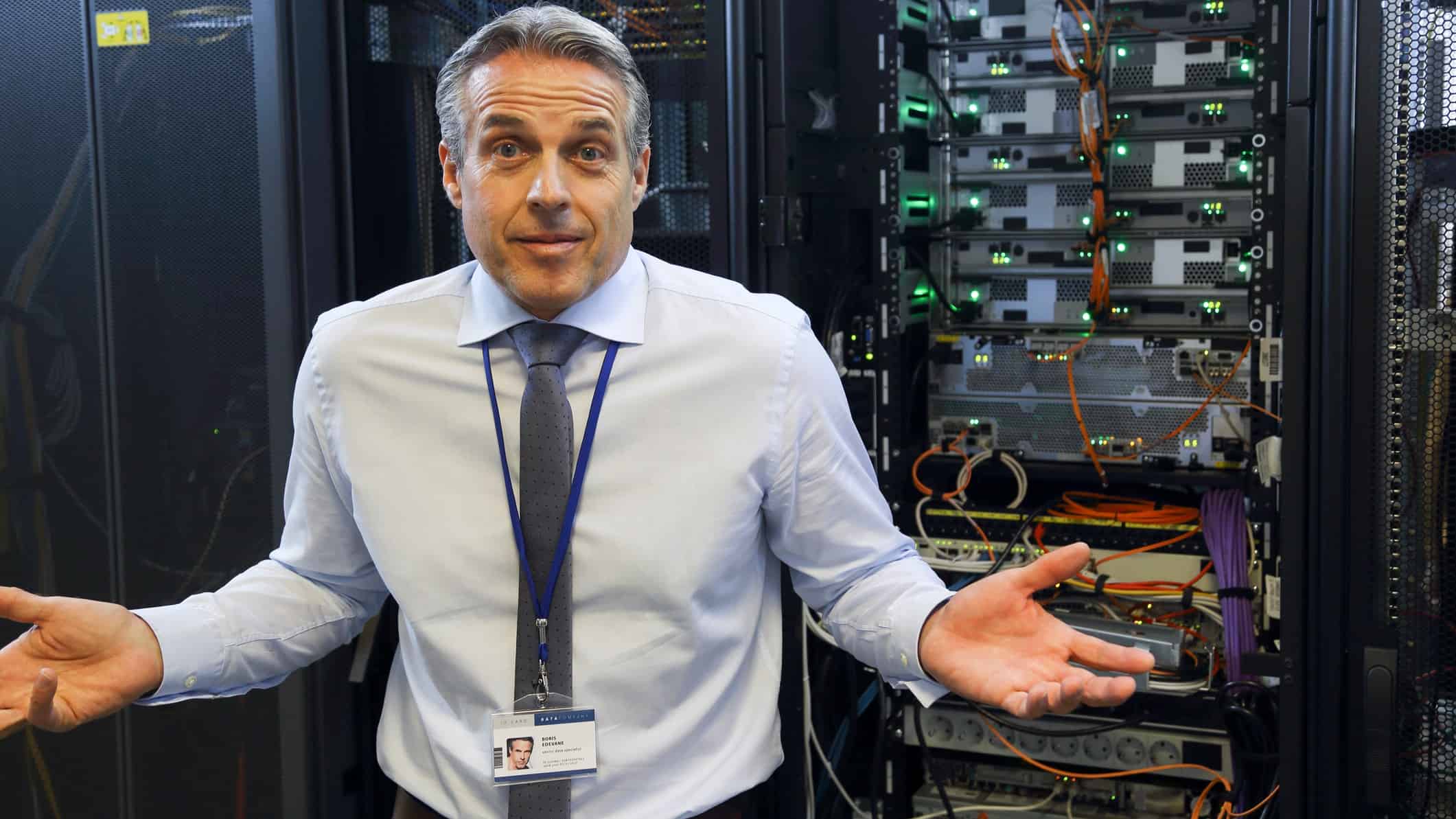 Male IT engineer shrugs his shoulders as he tries to understand network.