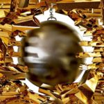 A wrecking ball swings through a wall of gold bricks, sending them flying.