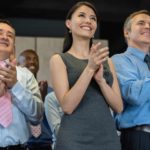 A group of happy corporate bankers clap hands