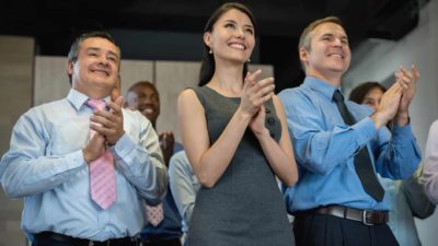 A group of happy corporate bankers clap hands