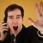 Man holding phone to ear shouts while hjolding out hand in stop motion