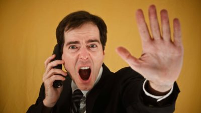 Man holding phone to ear shouts while hjolding out hand in stop motion