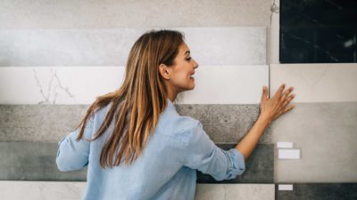 A smiling woman with a display of indoor tiles