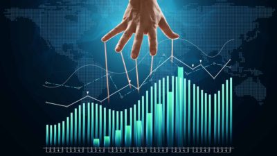 A hand descends above a share graph indication market manipulation