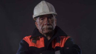 Older mine worker in hard hat looks upset