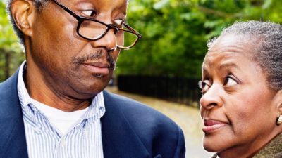 Elderly couple look sideways at each other in mild disagreement
