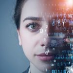 a woman stares ahead with a serious expression on her face while half of her face is covered by computer coding, indicative of artificial intelligence and machine learning technology.