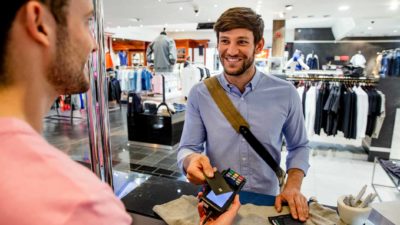 A young man in a retail shop pays for his purchases using a card