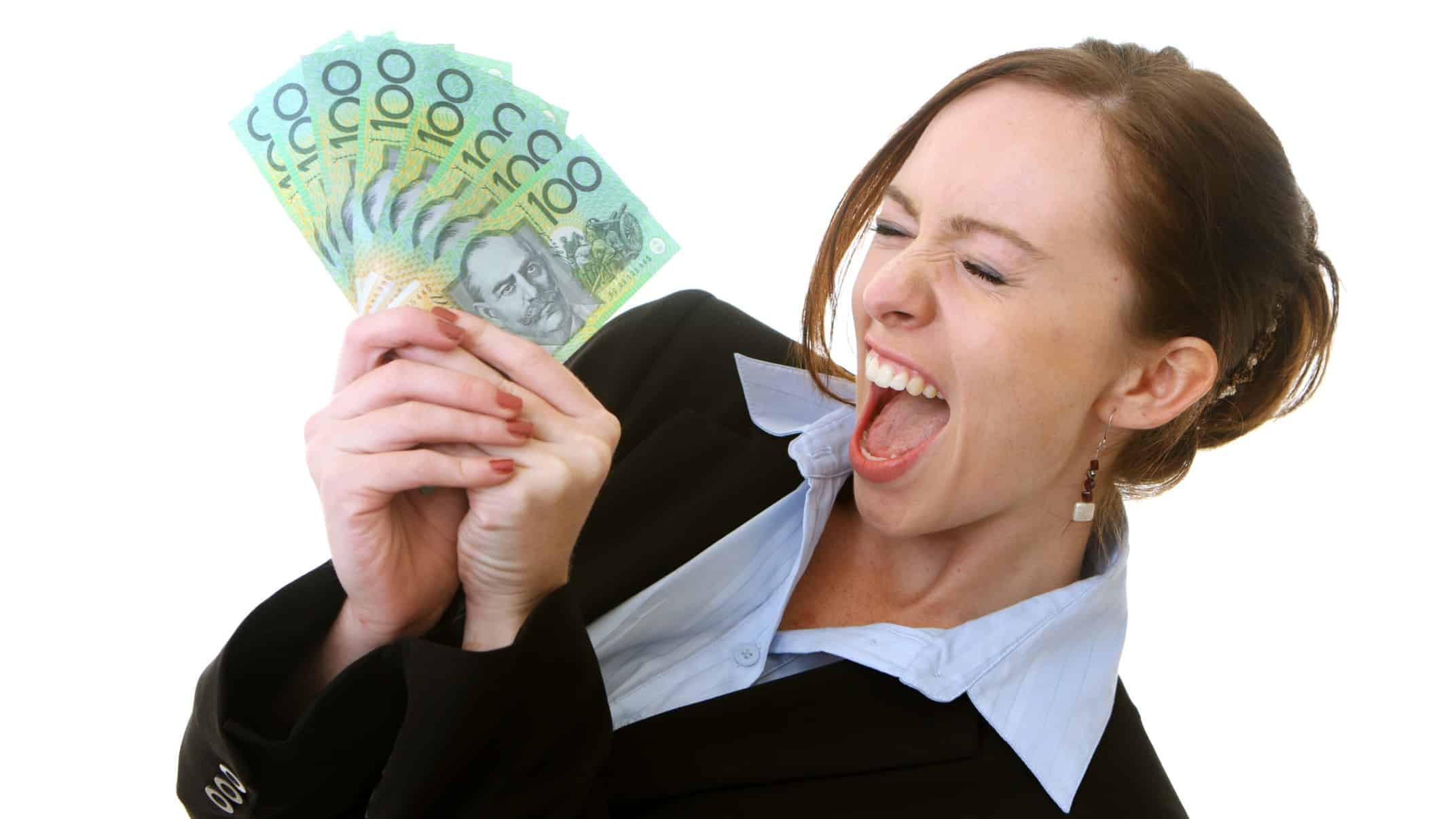 A business woman holding a wad of cash celebrates a dividends windfall