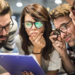 Group of thoughtful business people with eyeglasses reading documents in the office.