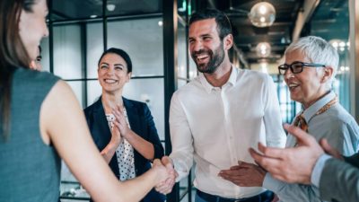 Cheerful businesspeople shaking hands in the office.