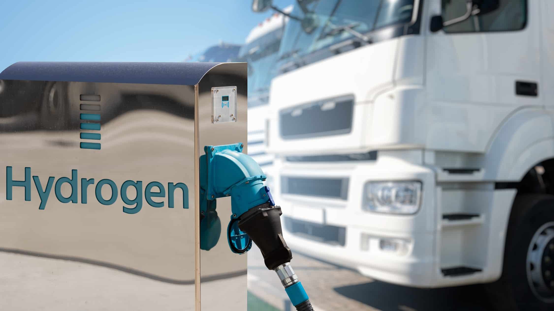 Hydrogen filling station with a background of trucks.