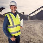 Miner standing and smiling in a mine field.