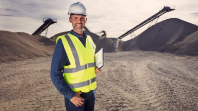 Miner standing and smiling in a mine field.